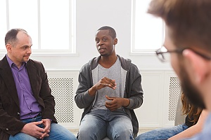 three men sitting in group therapy for Addiction Treatment & Therapies