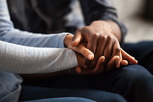 two people holding hands in a support group during outpatient programs