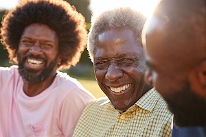 three men sitting outside doing peer support during Continuing Care