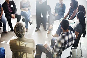 person standing and speaking at an addiction recovery support group meeting