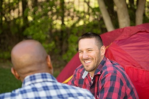 two men sitting outside camping